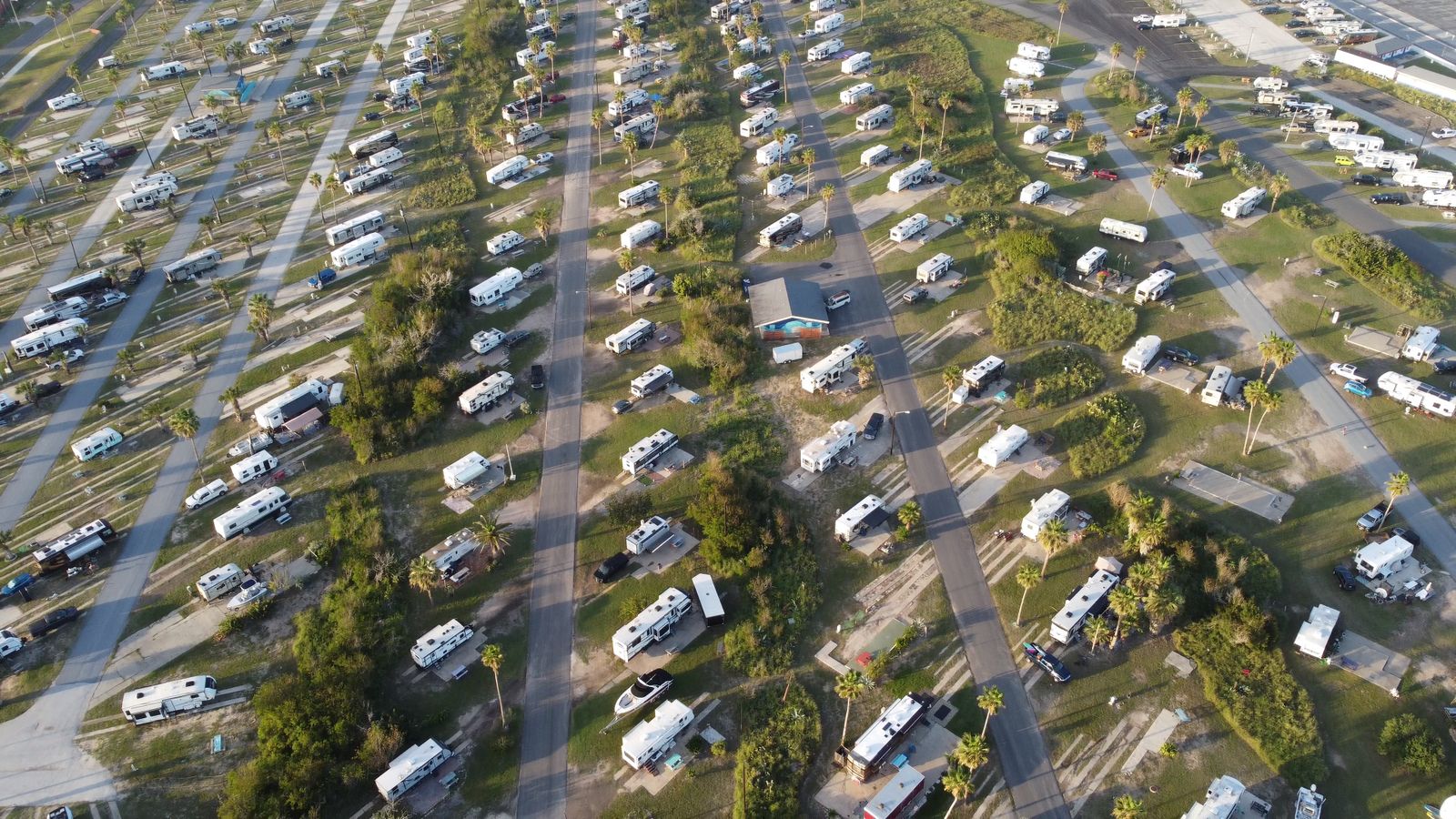 Vista aérea de um acampamento com vários motorhomes e trailers