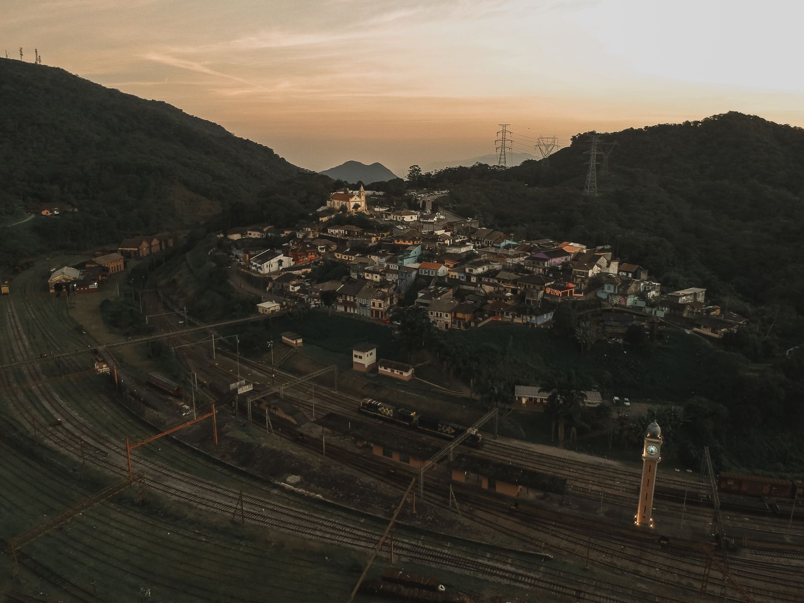 Cidade entre morros ao entardecer