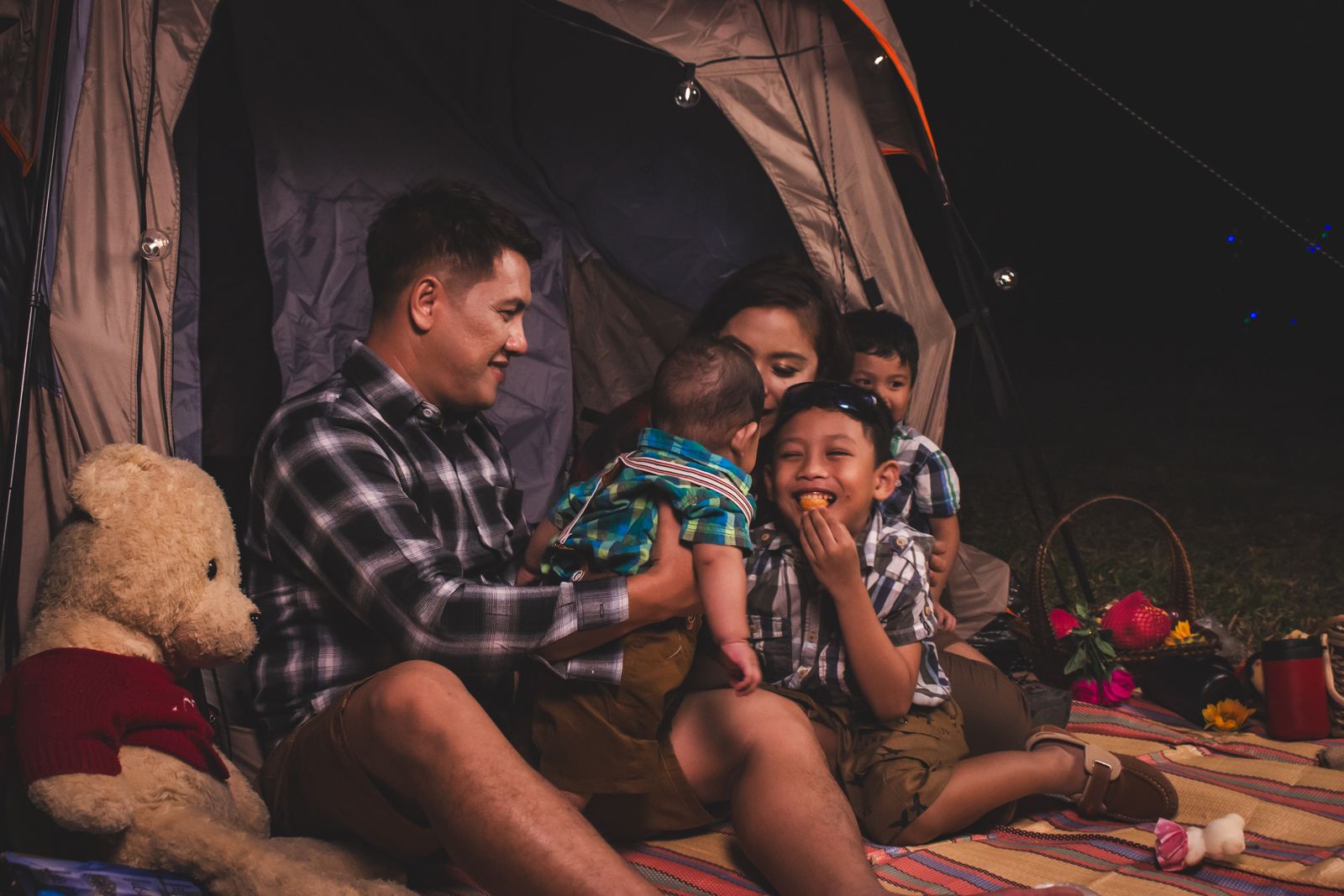 Família montando acampamento ao lado de uma barraca