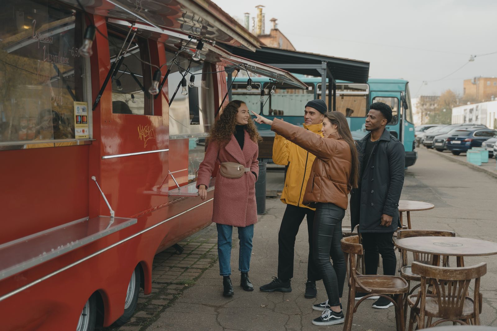 Pessoas conversando ao lado de um food truck vermelho