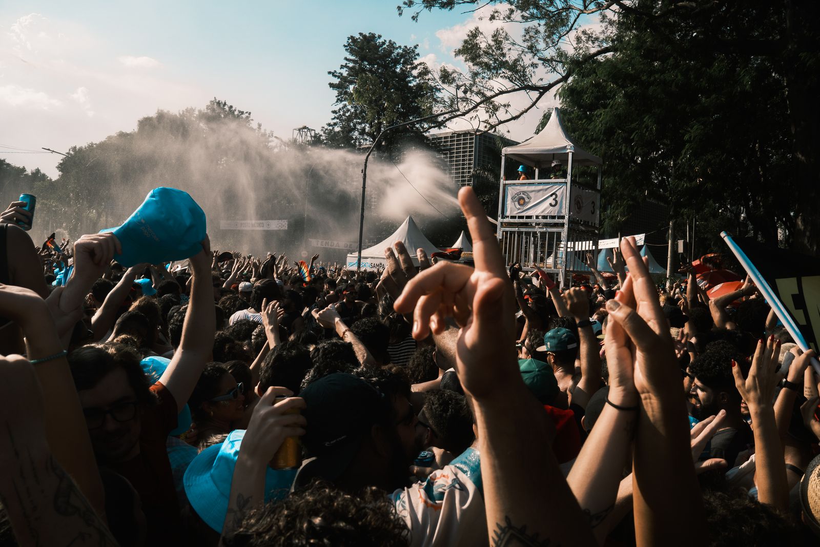 Plateia com os braços para o alto num show ao ar livre
